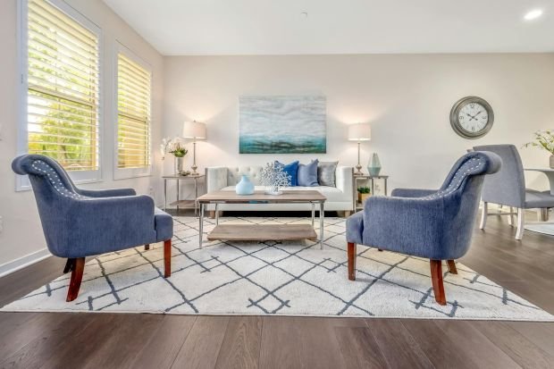 Spacious living room with stylish blue chairs and decor.