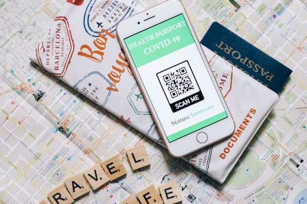 Smartphone displaying COVID-19 health passport on map indicating safe travel.